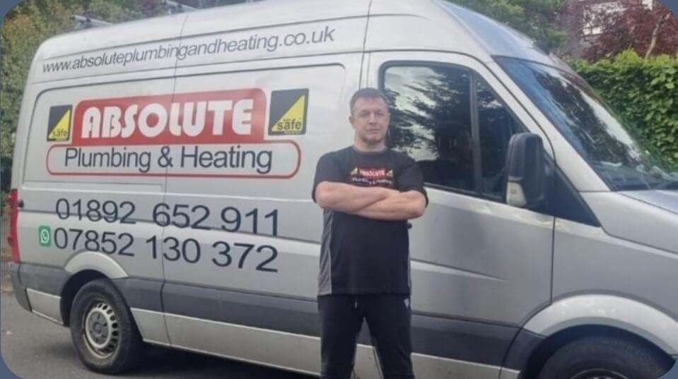 Daniel from Absolute Plumbing & Heating standing proudly in front of branded work van in Crowborough