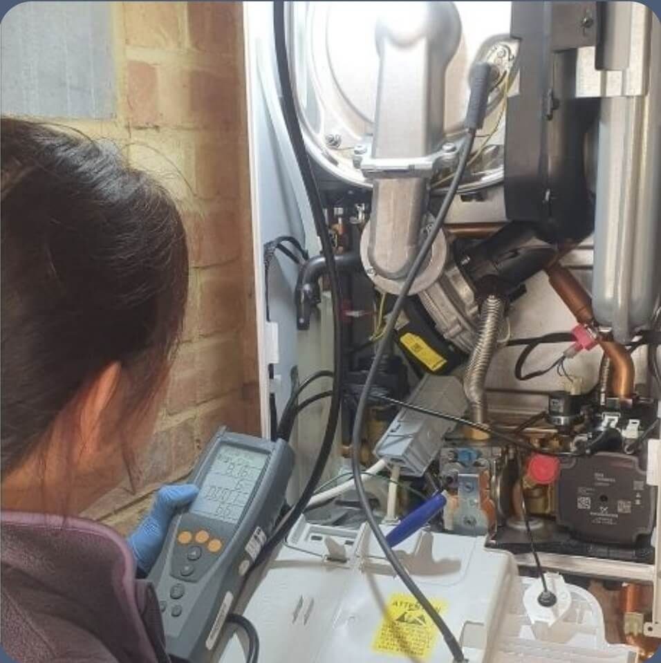 Engineer performing a flue gas analysis on an open Worcester boiler using a digital analyser — gas safety check in Crowborough.