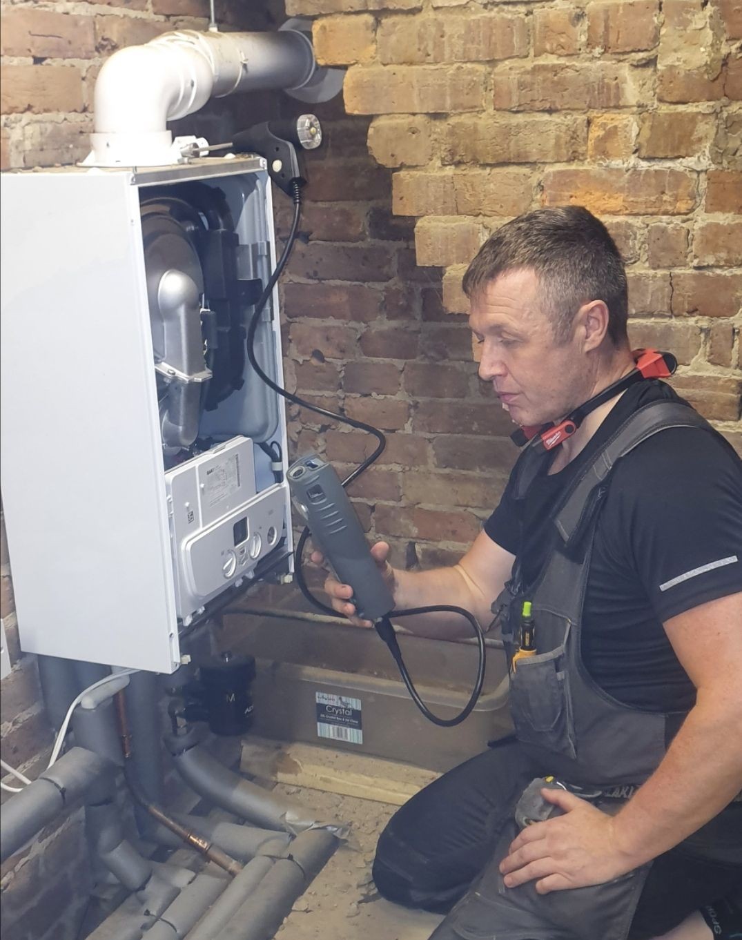 Gas Safe registered engineer performing a boiler service in Wadhurst, using a flue gas analyser to check combustion performance.