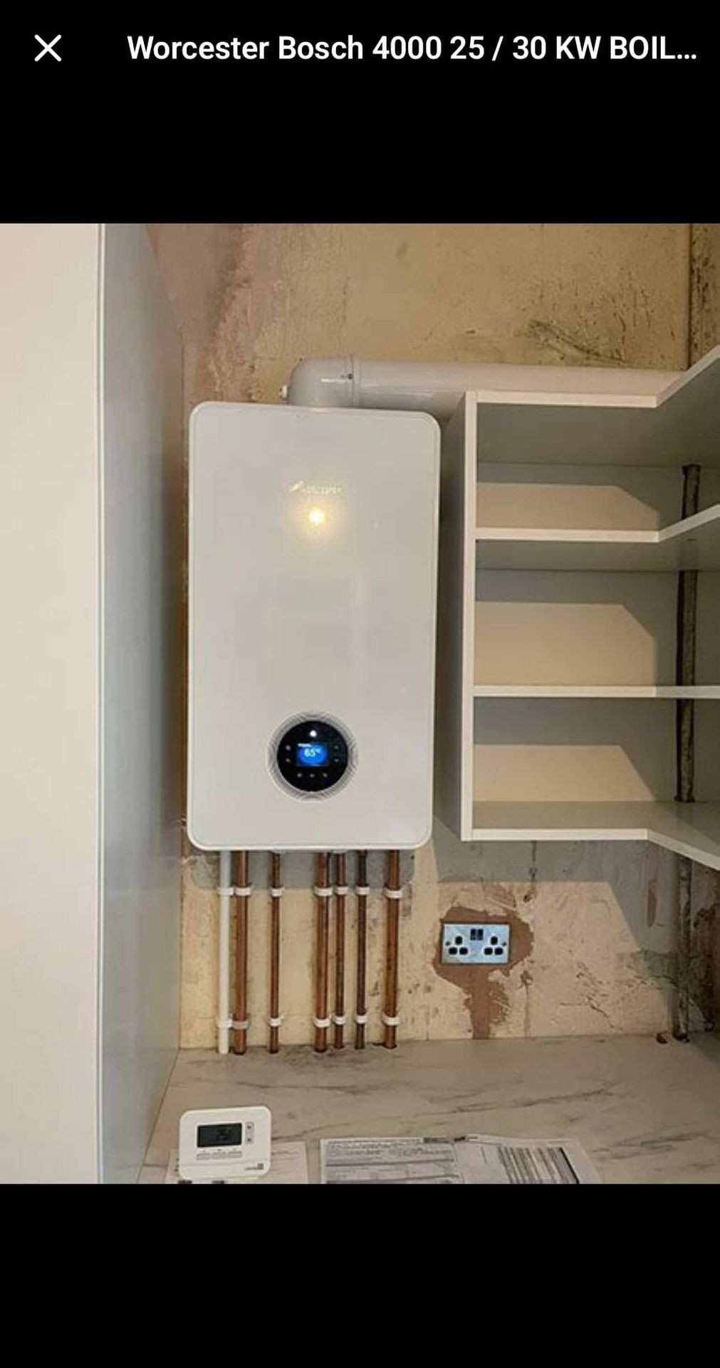 Brand new Worcester Bosch combi boiler installed in Uckfield with digital display set to 65°C – neat finish with surrounding shelving.