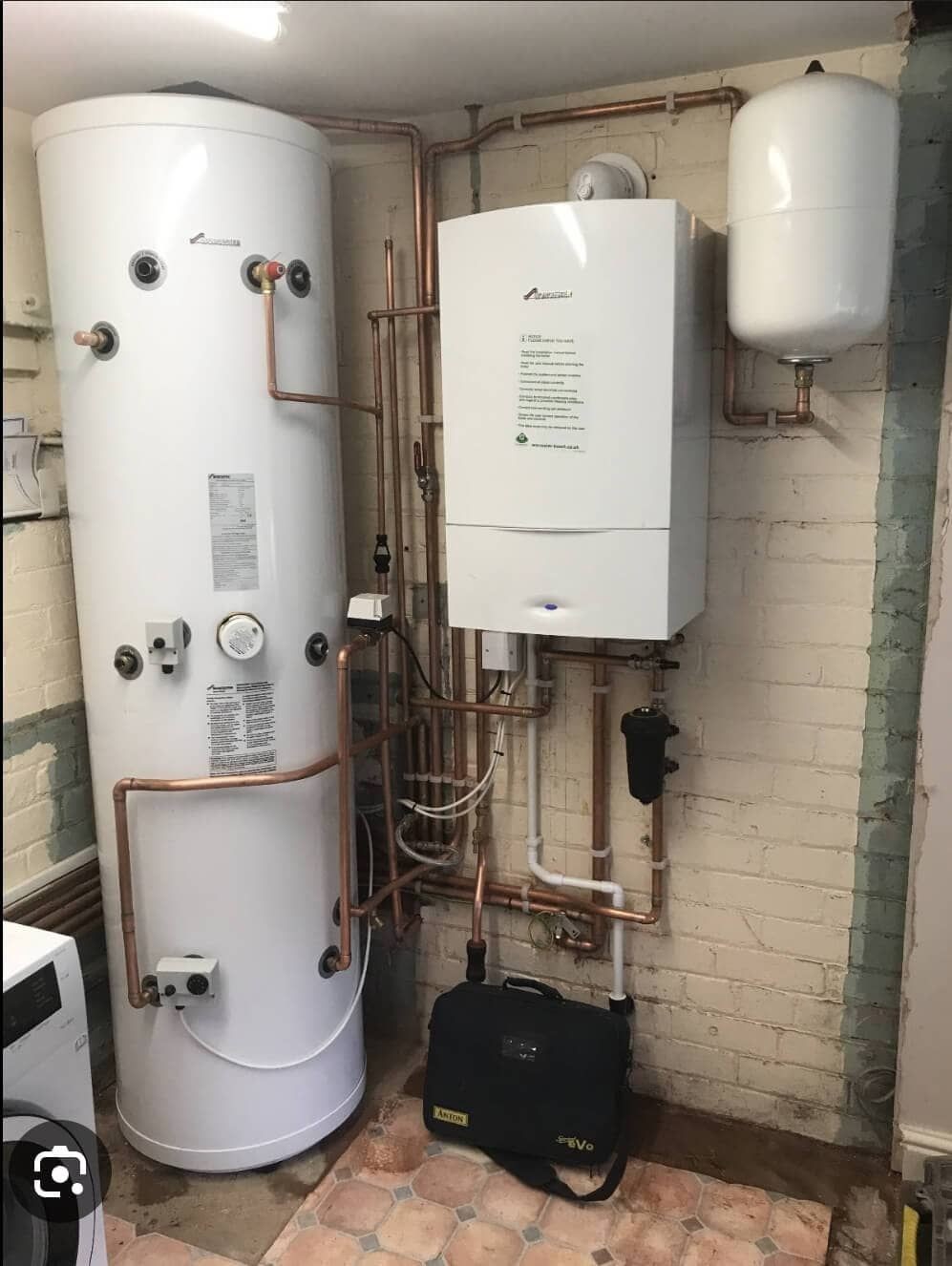 New boiler and unvented hot water cylinder installation in Uckfield, with neatly arranged copper pipework and magnetic system filter.