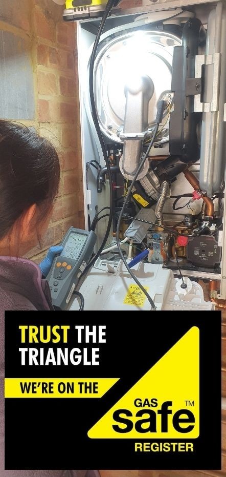“Local Gas Safe engineer smiling next to a white boiler, ready to carry out a Landlord Gas Safety Check (CP12).”