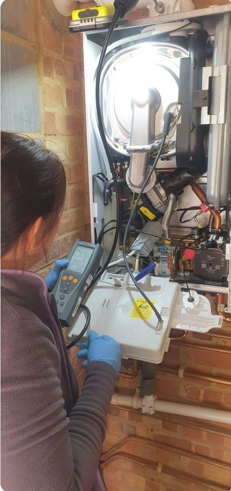 Engineer performing a flue gas analysis on an open Worcester boiler using a digital analyser — gas safety check in Crowborough.