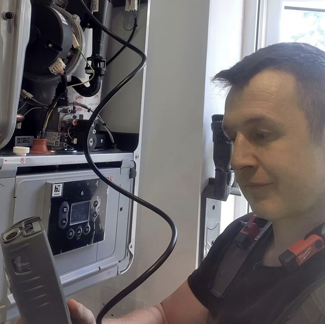 Daniel from Absolute Plumbing & Heating inspecting a boiler during a service visit near Tunbridge Wells.