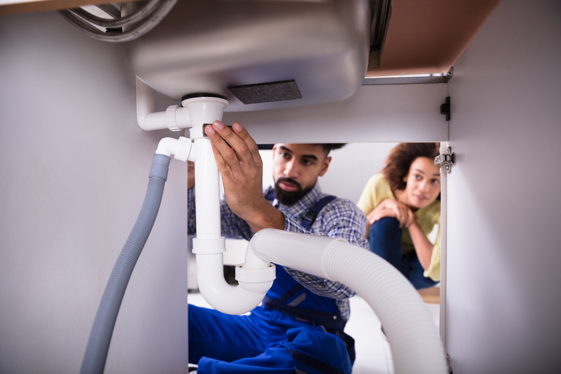 Close-up Of A Plumber Fixing Sink Pipe